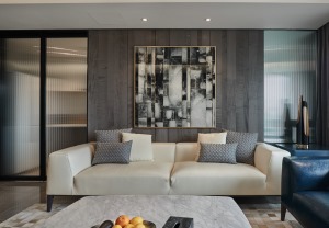 客厅以灰色为主，皮质沙发搭配大理石方形茶几，四角做了弧形的设计，减少尖锐的碰撞。