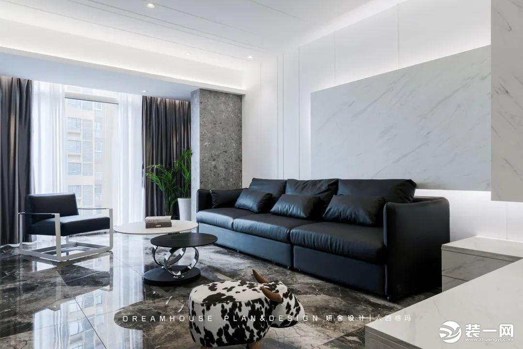 沙发墙同样是鲜明的极简调性，黑色真皮沙发+造型独特的圆形双茶几，赋予空间以随性不羁的格调。