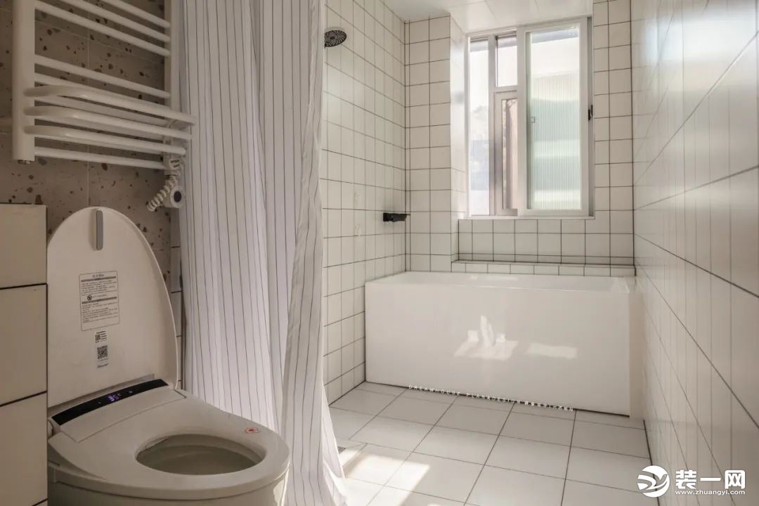 淋浴区用浴帘隔开，沿着窗户做了落地的浴缸。