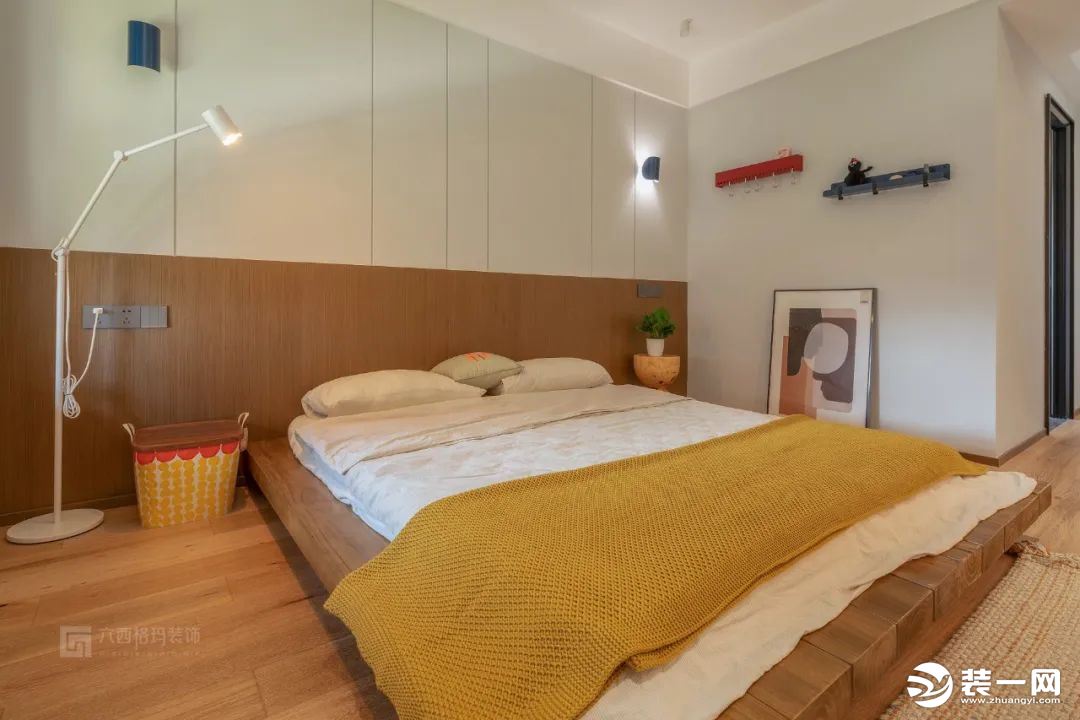 床头背景墙，灰白与木色上下形成拼色设计，使空间更为整体统一，更有格调感。