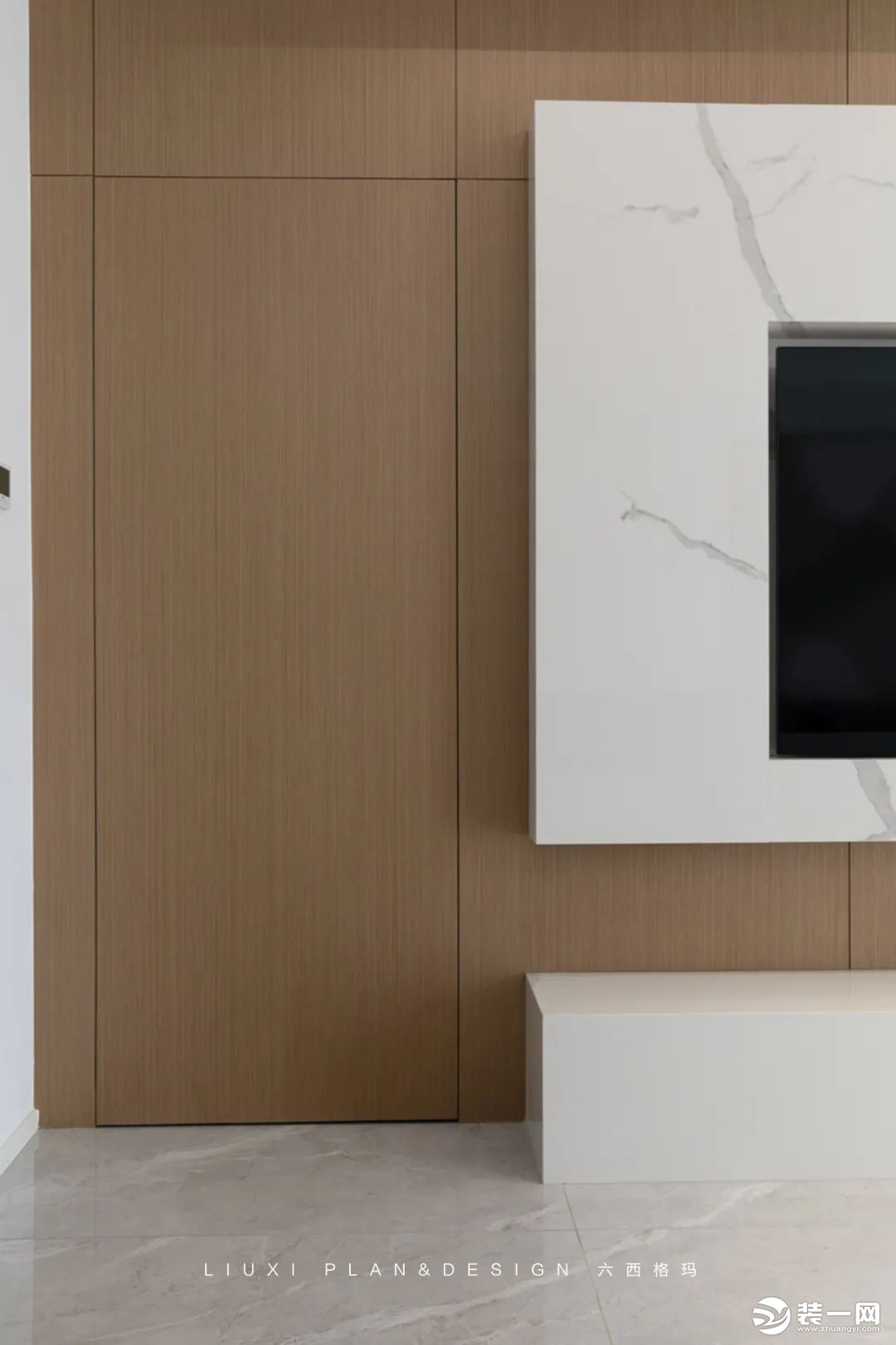 有了木饰面的加持后，电视墙左侧通往次卧的隐形门在材质和颜色上达成统一，做到了真正的“隐形”。