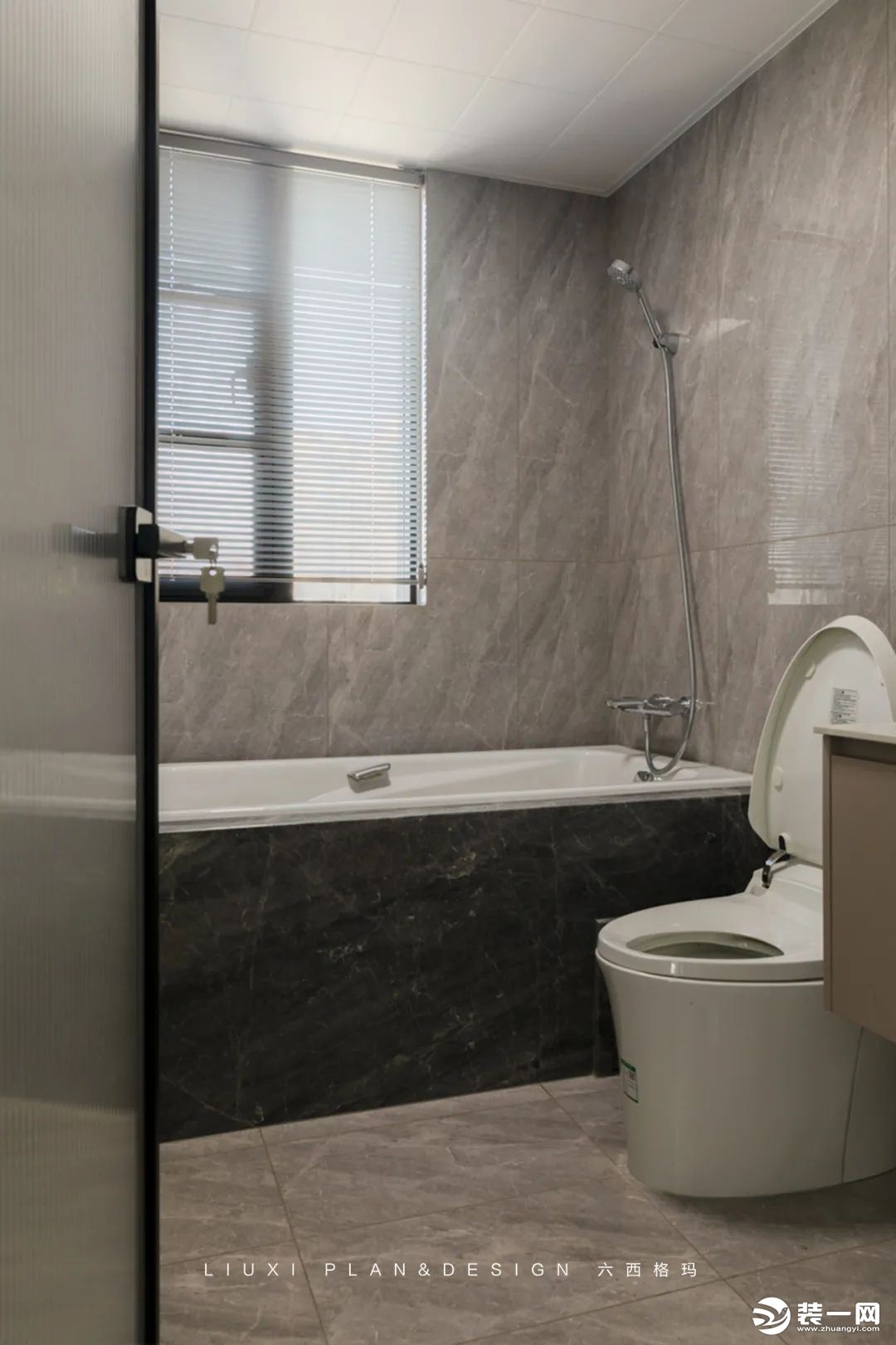 卫生间灰色系瓷砖延展空间，内敛质感十足。悬空浴室柜设计，便于日常清洁卫生。 现场砖砌浴缸经济实用，阳