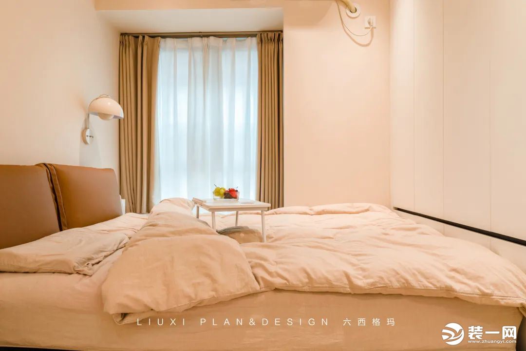 主卧用温柔的奶茶色和咖色，渲染出一种优雅又私密的空间氛围，带来浓浓的安全感。床尾设计了满墙的衣柜，满