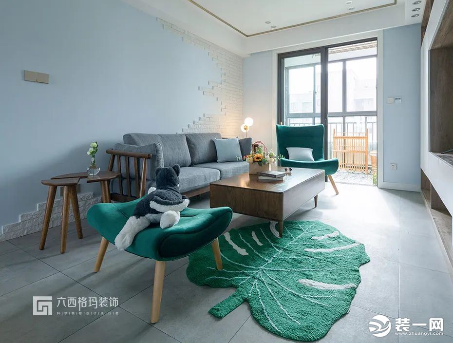 大量原木色點綴的客廳內擺一張深綠色的單人椅，配以同色的樹葉造型地毯，用深深淺淺的綠色布置出春意，讓人