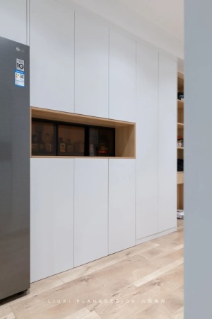 收纳柜采用一门到顶的设计，整体色调为白色，加以木色点缀，营造出简约舒适自然风。