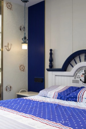 男孩房床头以长城板+硬包背景墙的基础，布置一张白色拱形靠背床，搭配活力的蓝色调床品，上方挂一盏独特的