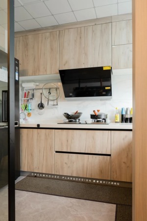 黑色大冰箱摆放在了厨房的一侧，以灰色地砖搭配木色橱柜，过渡到白色台面和墙砖，打造出一个简洁明快的烹饪
