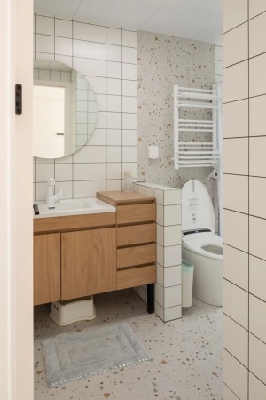 卫生间简洁明亮，小白砖和水磨石铺贴组成黄金CP，搭配效果相当貌美。