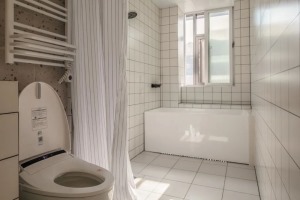 淋浴区用浴帘隔开，沿着窗户做了落地的浴缸。