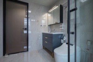 壁挂马桶+浴室柜+镜柜，搭配上灰色的墙地砖，看起来非常现代时尚。在灰白为主打的空间里，灰蓝色的浴室柜
