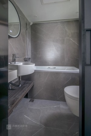 主卫墙地面铺贴600*1200的灰色大砖，搭配简洁的浴室柜。顶面使用防水石膏板，浴缸靠边，马桶和洗手