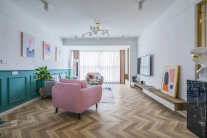 客厅地面通铺鱼骨拼木地板，整个空间的用色丰富多彩。长条形腾空的白色+木色电视柜增加了空间的层次感，视