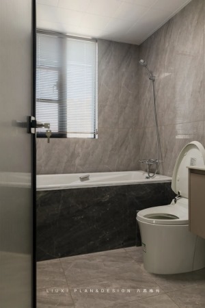 卫生间灰色系瓷砖延展空间，内敛质感十足。悬空浴室柜设计，便于日常清洁卫生。 现场砖砌浴缸经济实用，阳
