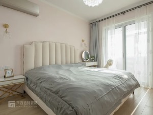 粉色调的卧室墙面，搭配米白色皮艺床，还有对称的黄铜玻璃壁灯，灰色系的床品和窗帘相互呼应，床头一边设床