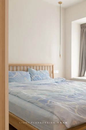 原木床搭配淡蓝色的床品，舒适恬静。躺在柔软的床上，白天疲惫的身心顷刻便能得到抚慰