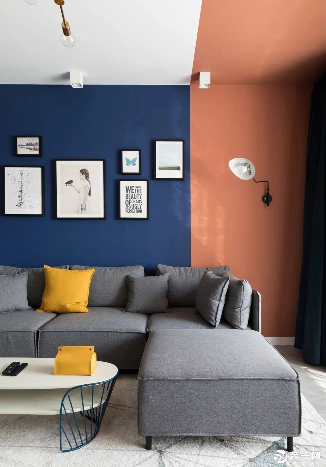 灰色沙发搭配弧形茶几 一抹黄色提亮视觉 背景用简框画与壁灯修饰