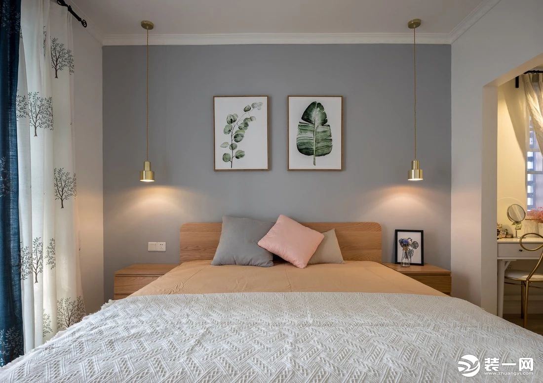 蓝白相搭的绣花树窗帘，与墙上挂画相互呼应，显得清新干净。铺上了暖色调床品的木质床，柔软舒适中带着自