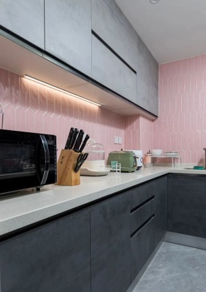 灰色地砖搭配灰色橱柜门 粉色的墙砖让料理 空间充满少女感 吊柜下方补充照明