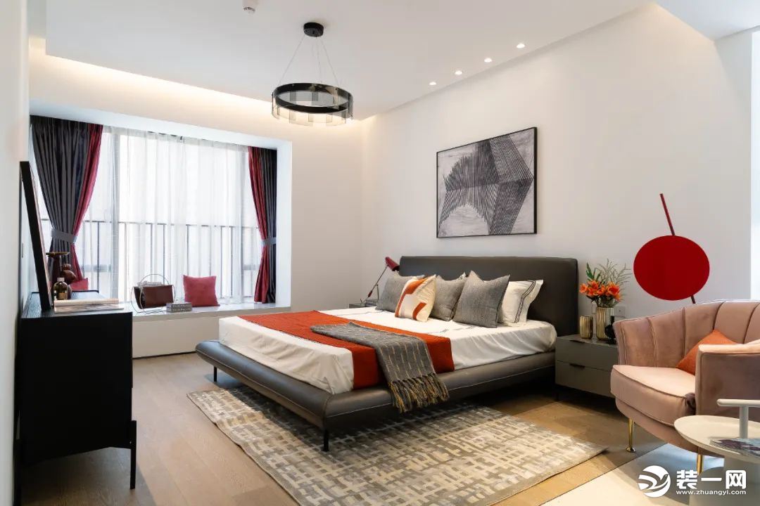 主卧部分延续了客厅风格，黑色皮质的大床舒适高级，加之红色床品的点缀，好看又吸睛。