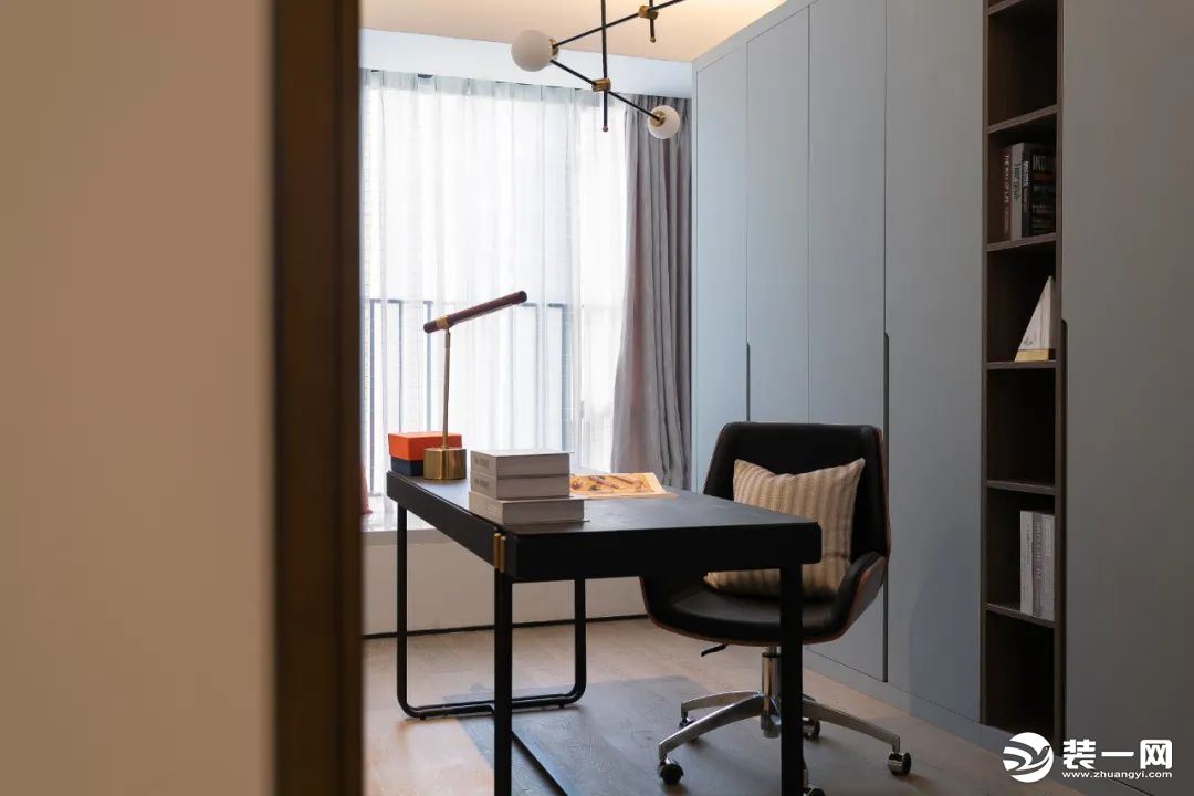 独立书房设计，简约的黑色书桌，深棕色的木质转椅，在暖色地板的衬托下，温馨又沉稳。