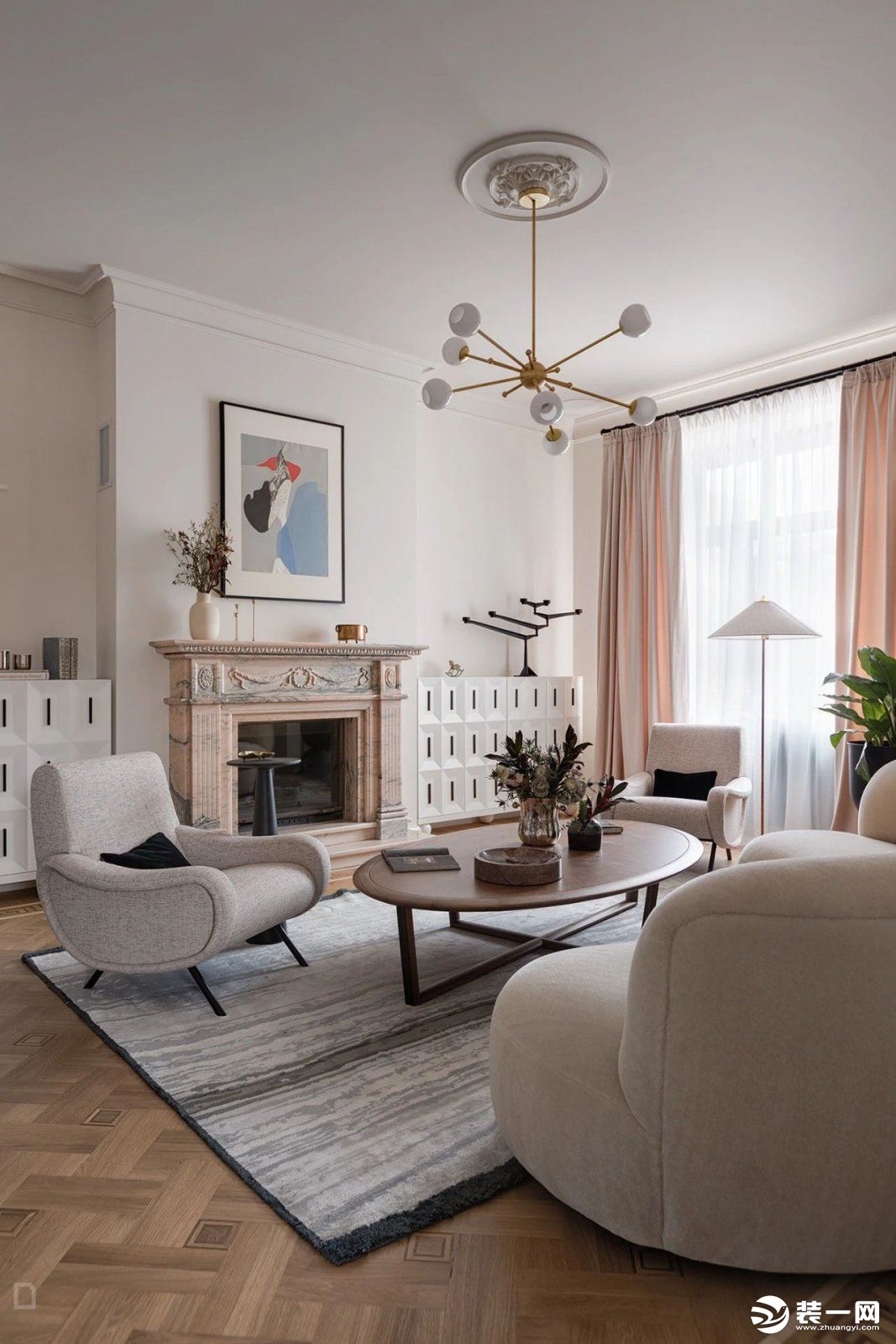 客厅质感细腻的奶油色调流露轻熟撩人的优雅魅力，长形沙发与两张扶手椅摆设于主体位置，把空间的柔和浪漫的