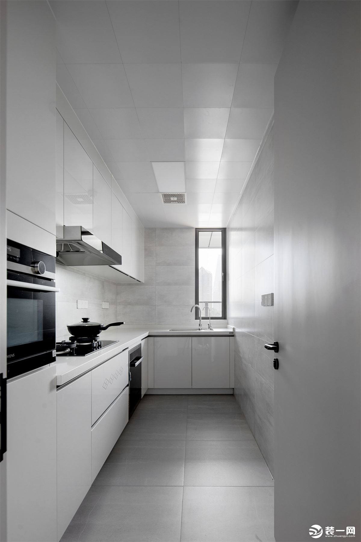 厨房素雅大气，浅灰色地砖搭配浅色纹理墙砖和白色橱柜，纯净的配色勾勒出简约大气的烹饪空间。