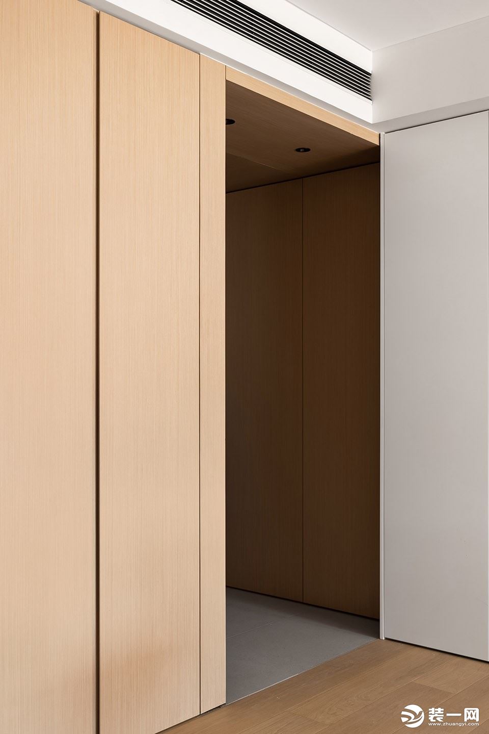 整个玄关采用木盒子的做法，与西厨厨柜相交，玄关左侧为一排通顶储物柜。