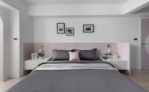 比如床头板就用粉色做成一个围栏，连同卧室门和主卫门一起构造粉色的连贯性，中性灰调的墙面和衣柜门平衡空