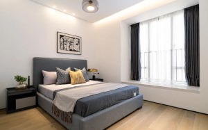 整体白色墙面和柜体，搭配深灰蓝色的床品，经典而通透的色调展现出一份优雅与闲适。