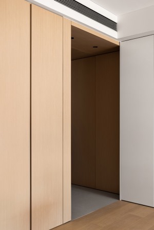 整個玄關采用木盒子的做法，與西廚廚柜相交，玄關左側為一排通頂儲物柜。