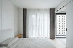 主卧的设计延续了空间的整体风格，以简约线条和色块打造宁静自然的睡眠空间，柔软之处体现于家具单品的质感