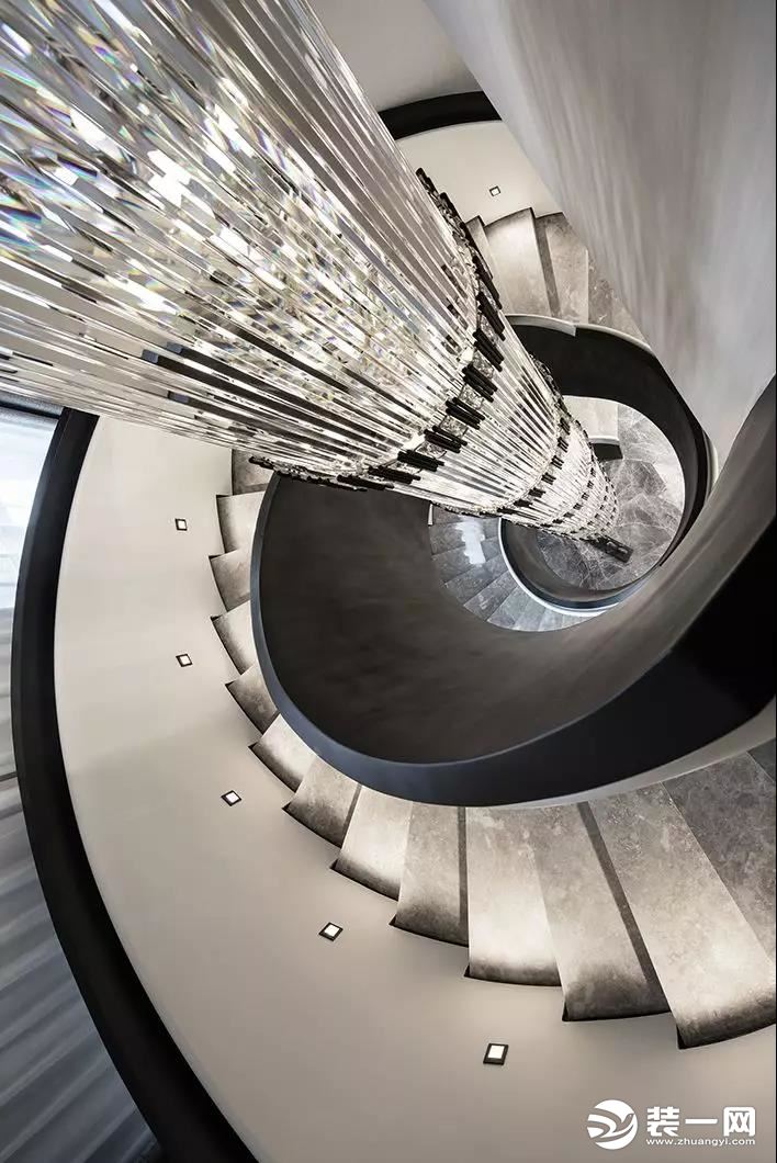 为空间量身定制的旋转楼梯，由折弯的钢板焊接而成，内外黑白分色氟碳漆处理，质感精致，极具雕塑感，与客厅