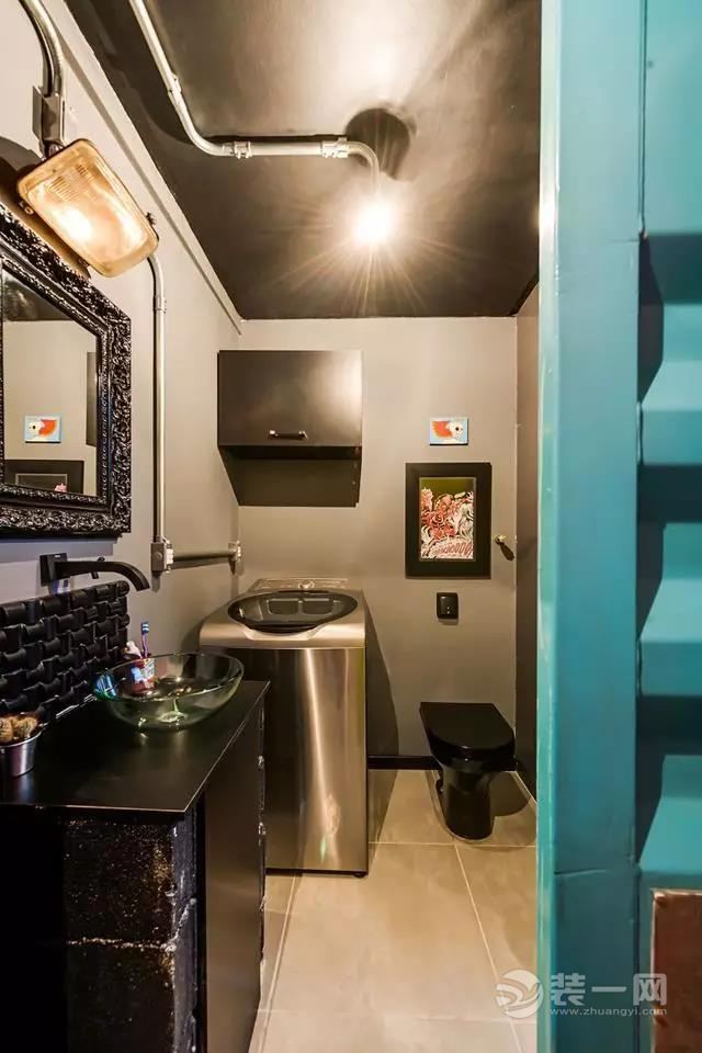 卫生间也被黑色所包围，不锈钢材质的洗衣机的放置让这个空间更加的充实。