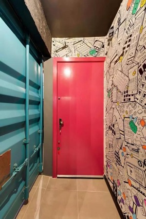 进门之后，走廊的颜色令人眼花缭乱，粉色的门以及被涂成蓝色的铁艺墙，更值得注意的是墙壁的涂鸦，表明了9