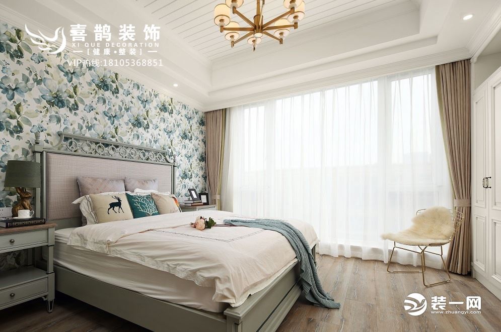 卧室比较简洁，壁纸是蓝色花卉，美式风的床，北欧风的凳子，整体显得时尚耐看。