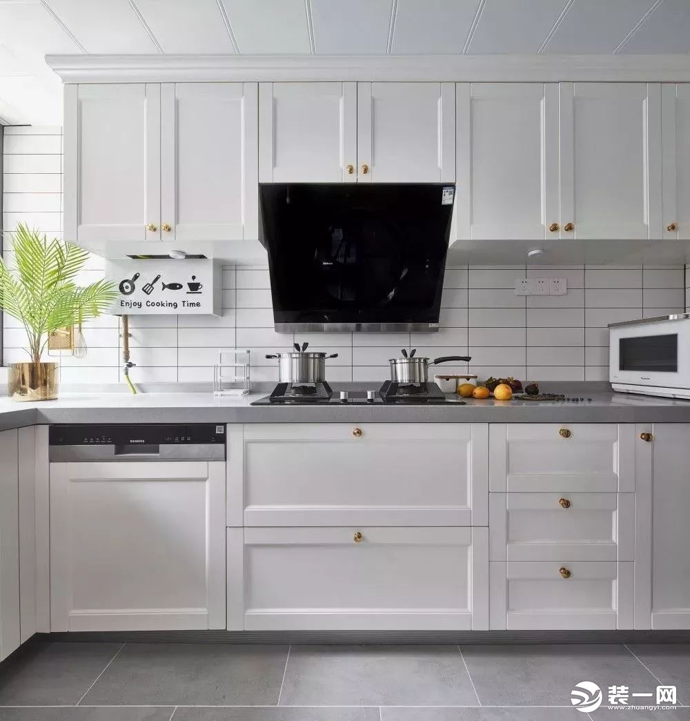 厨房内部空间宽敞，做了L型的橱柜布局，以灰色和白色为主的厨房，搭配绿植、金属元素作为点缀，给人一种年