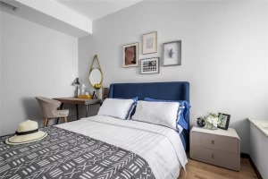 深蓝色的床搭配低明度的墙，奠定了空间沉稳、冷静的基调