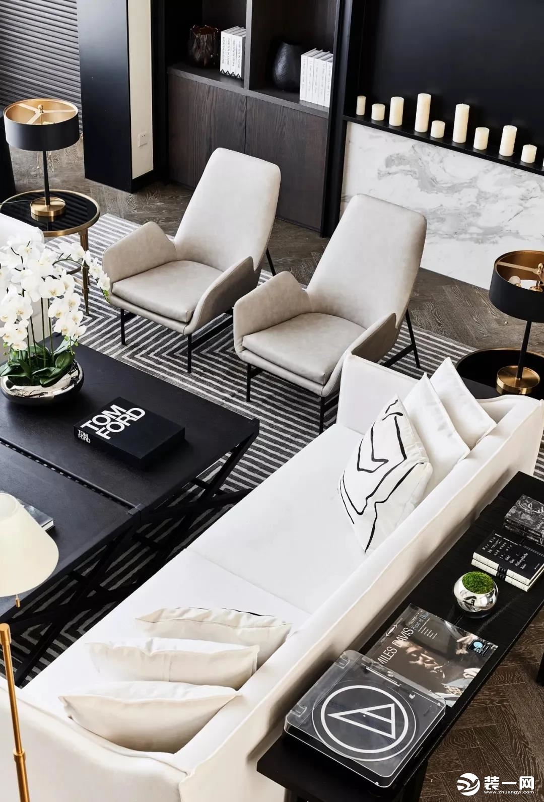 宽大的米白色布艺沙发，地面上还有黑白条纹的地毯，黑白配的空间，布置出舒适优雅的华丽气质