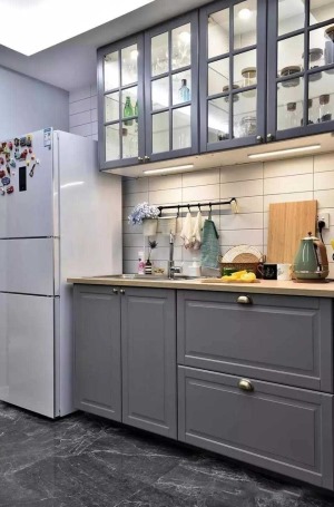 西安路80㎡北欧风格两居室厨房效果图厨房顶部用透明玻璃的橱柜，放置餐具等，还安插了节能灯照明又烘托氛