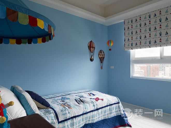 蓝色调的男孩房中，在墙上贴饰热气球壁饰，营造漂浮在蓝天上作梦的男孩风梦幻。