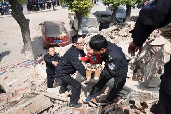  4月11日，救援人员从房屋废墟中救出一名男童。上海装修网供图