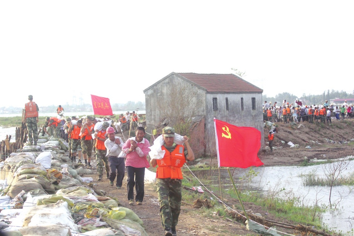 望江县漳湖镇五九圩大湾段，党员干部群众和武警官兵在抢险。
