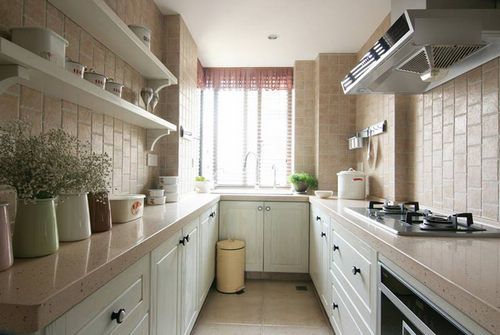 厨房的橱柜也是定制的，粉红人造石的台面和带有怀旧气息的仿古墙面砖相呼应着。空间整体的色调是如此的柔和，想必主人在打造时花费了多少心思