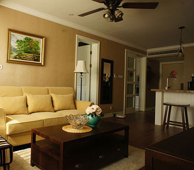 走过吧台区看到的就是客厅了，客厅的空间不大，放下一张米黄色的布艺三人沙发和一张条纹的单人沙发。一副美式风情的画面